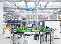 Industrial production line inside a modern factory with conveyor system and automated machines.