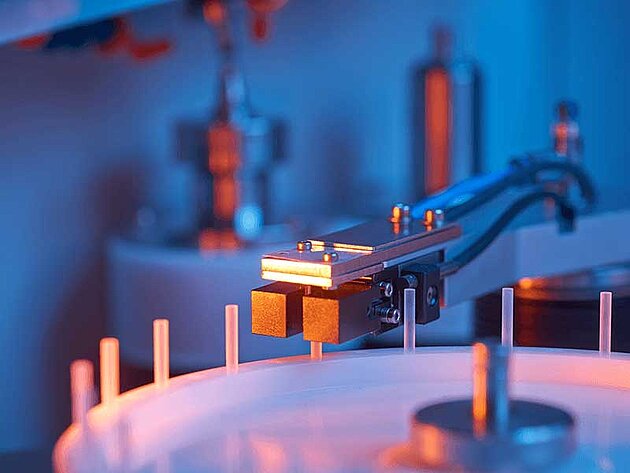 Close-up of industrial machine with sensor arm positioned over circular component
