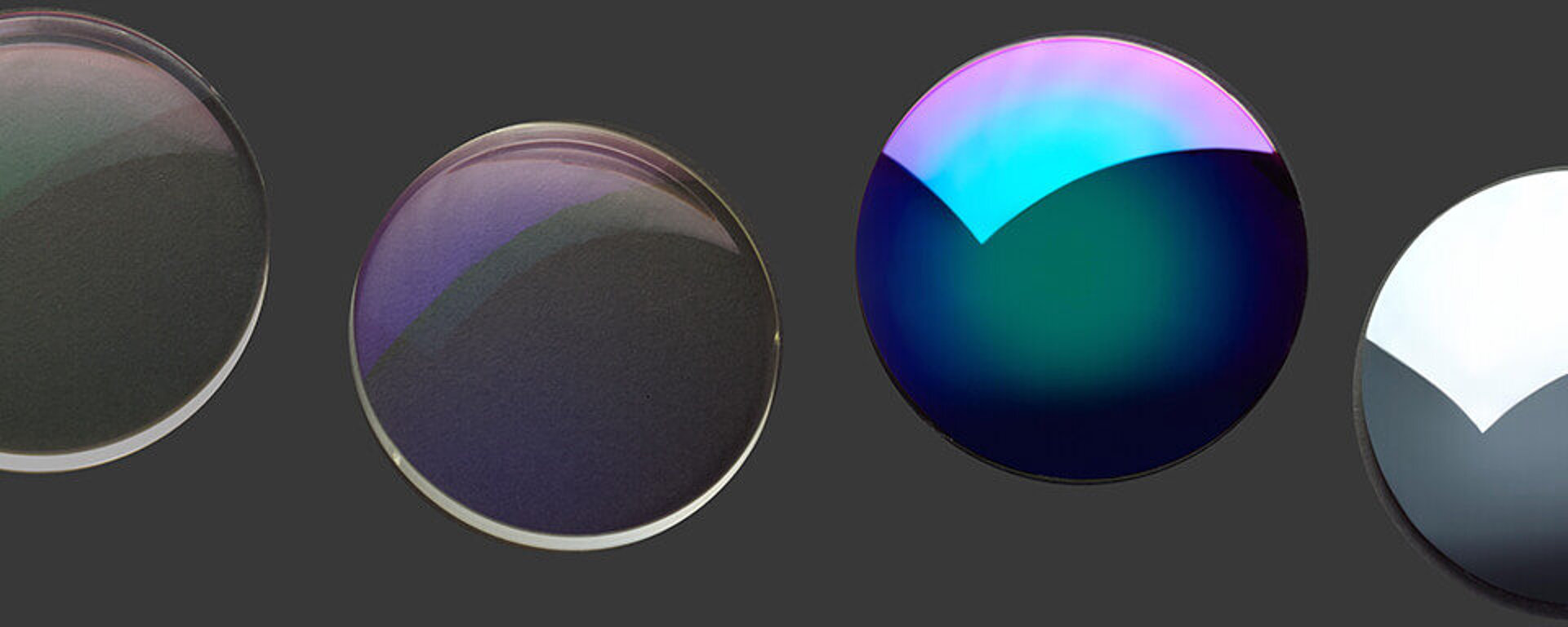 Row of optical lenses with different reflective coatings in various colors.