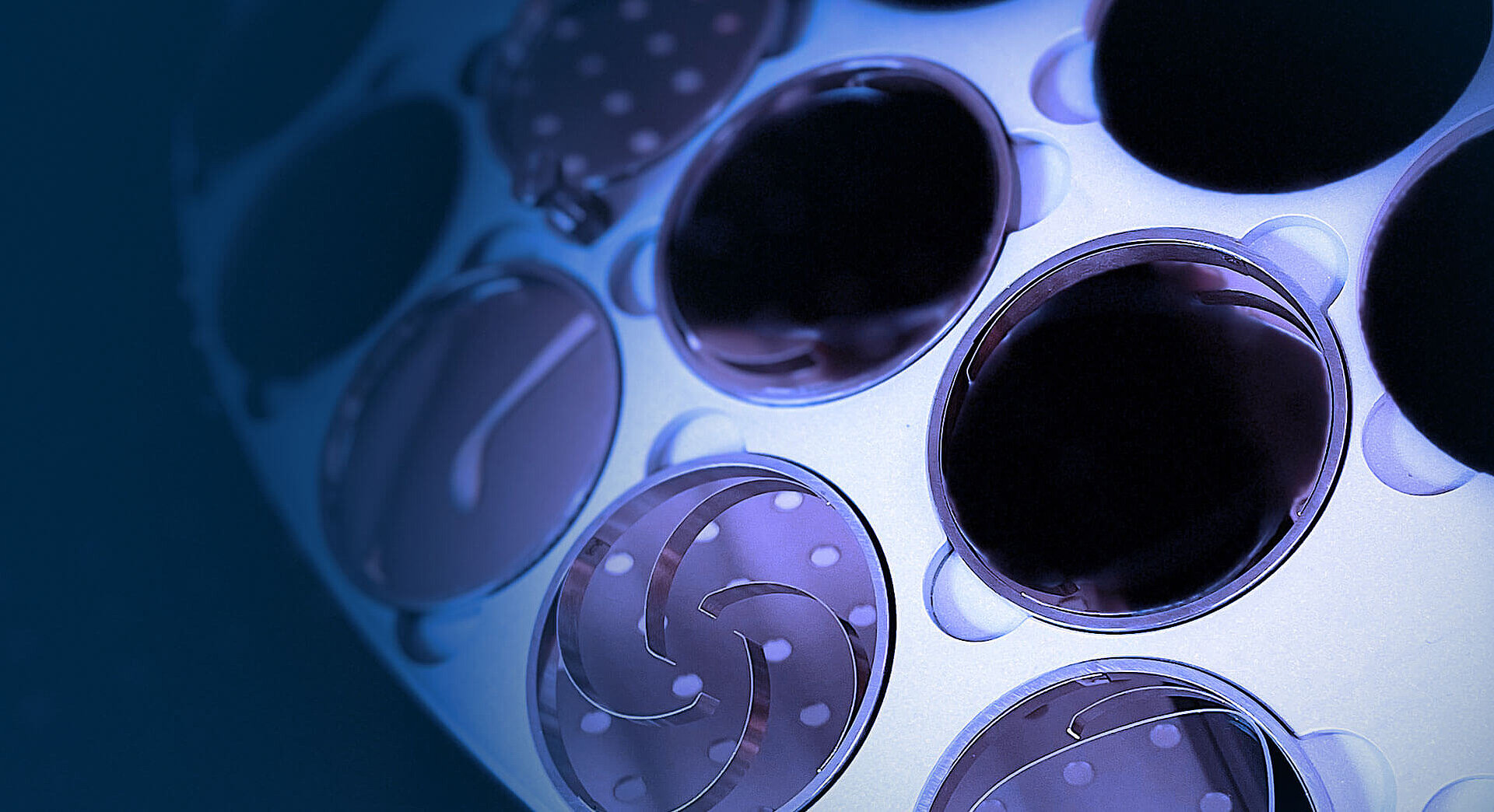 Close-up of ophthalmic lenses inside a Satisloh coating machine dome.