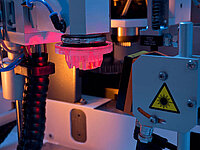 Industrial machine with precision tool head and sensors during an automated manufacturing process.