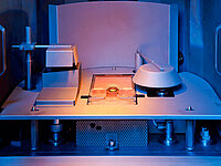 Interior of a vacuum coating machine showing components used for lens processing.