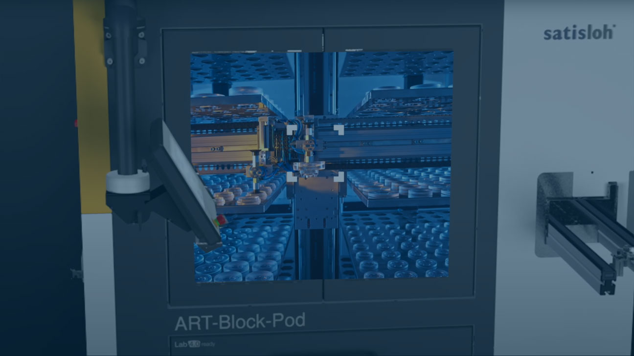 Close-up of an automated laboratory machine with a viewing window showing rows of vials inside.